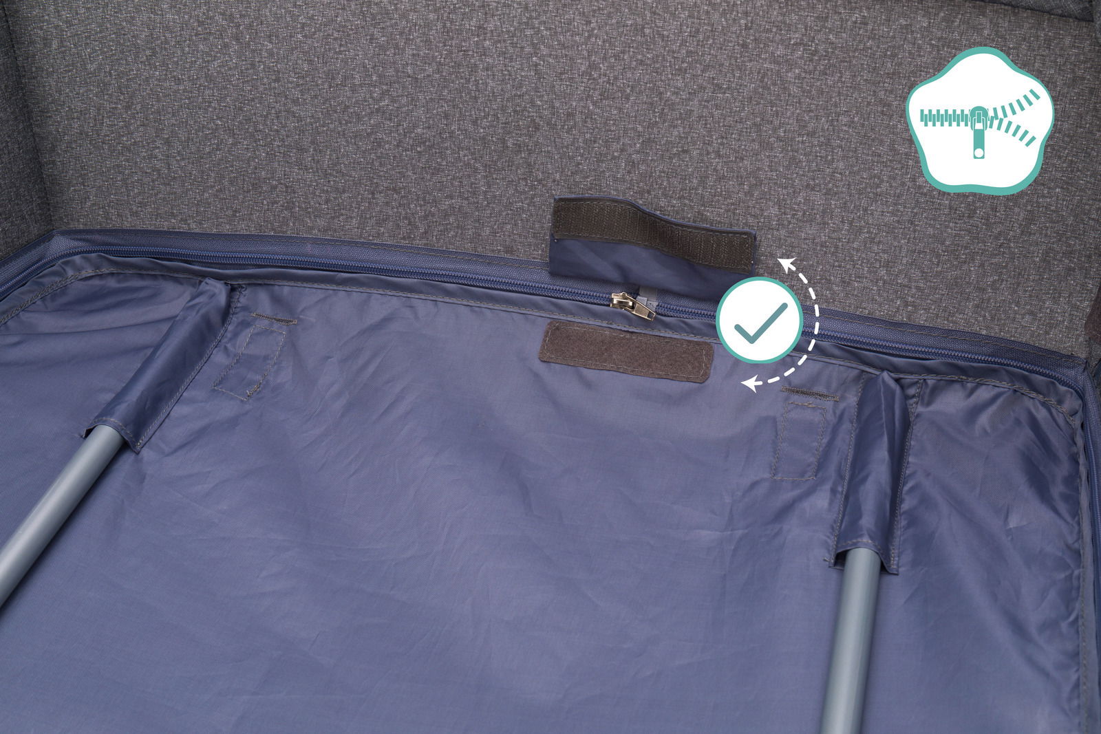 Innenansicht eines Reisebetts mit grauem Stoff und Reißverschluss, von oben fotografiert.