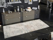 Frisé-Teppich in einem modernen Wohnzimmer, von oben betrachtet, mit einem dezenten, mehrfarbigen Muster auf dunklem Boden.