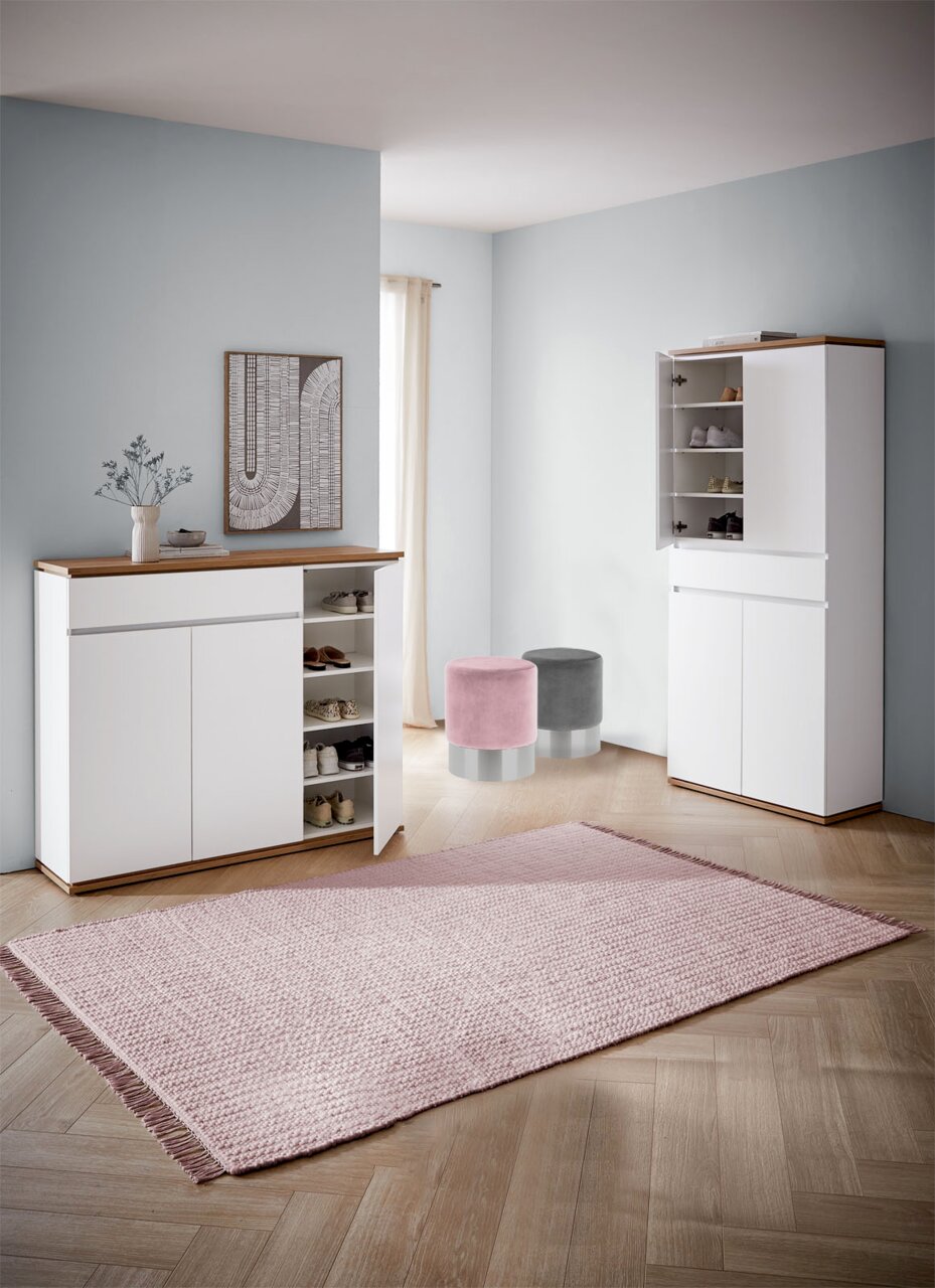 Moderner Eingangsbereich mit zwei weißen Schuhschränken, einem geöffneten, und zwei runden Hockern in Rosa und Grau, aus der Perspektive von vorne.