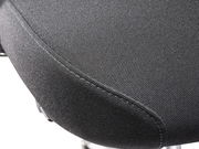 Nahaufnahme der Sitzfläche eines Chefsessels aus schwarzem Stoff, seitliche Perspektive