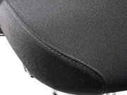 Nahaufnahme der Sitzfläche eines Chefsessels aus schwarzem Stoff, seitliche Perspektive