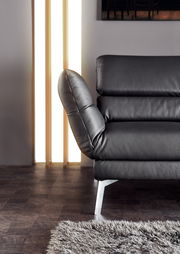 Nahaufnahme eines schwarzen Ledersofas mit verstellbarer Rückenlehne und Metallfüßen, seitliche Perspektive.