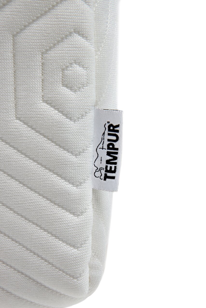 Close-up van een Tempur Visco-matras met geometrisch patroon en merklabel, gezien vanaf de zijkant