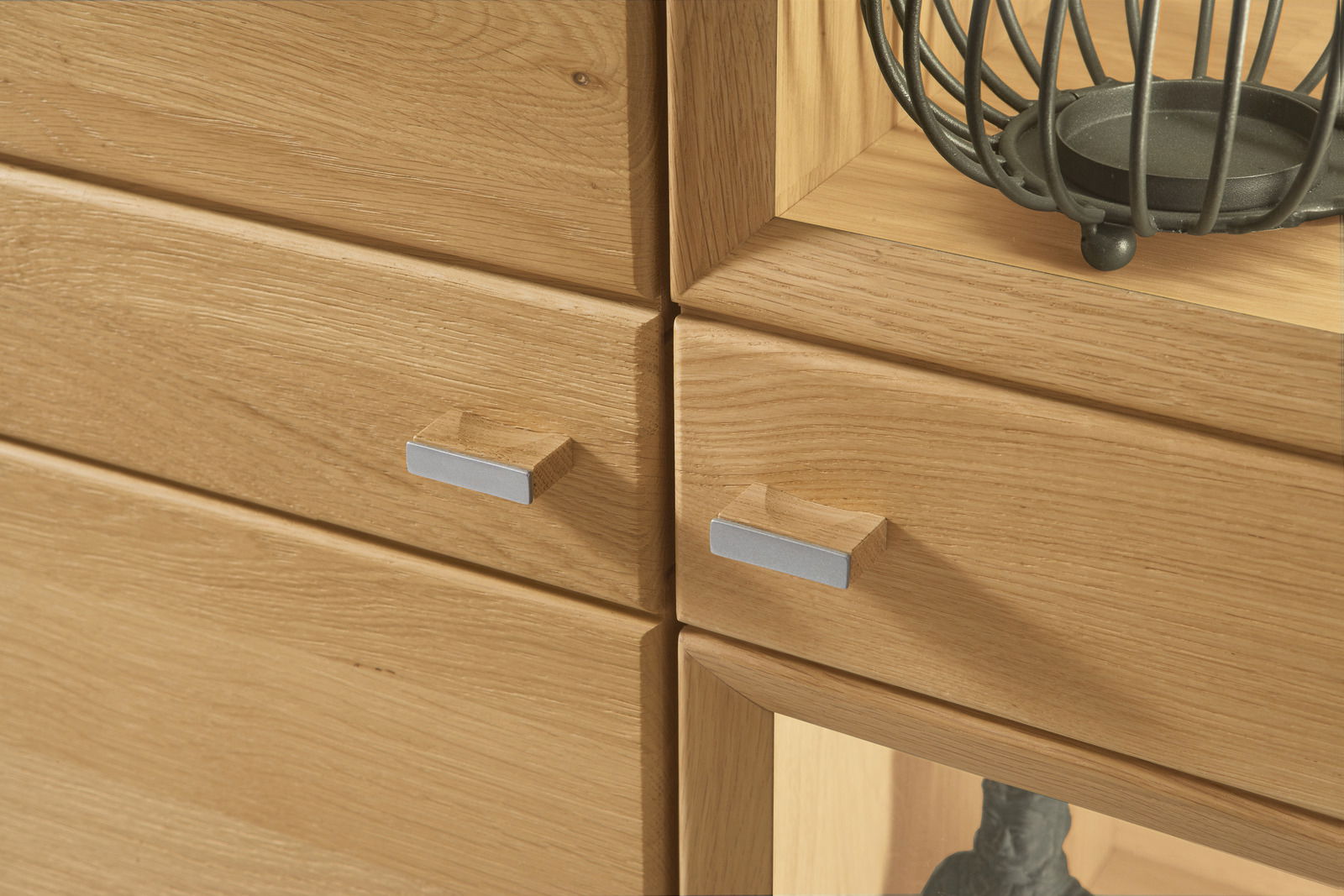 Nahaufnahme einer Wandkombination aus Holz mit modernen Metallgriffen, seitliche Perspektive