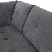 Graue Stoff-Rundecke mit gepolsterten Kissen, Nahaufnahme von der linken Seite.