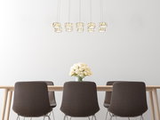 Moderne Hängeleuchte mit mehreren Leuchtkörpern über einem Esstisch, seitliche Perspektive.