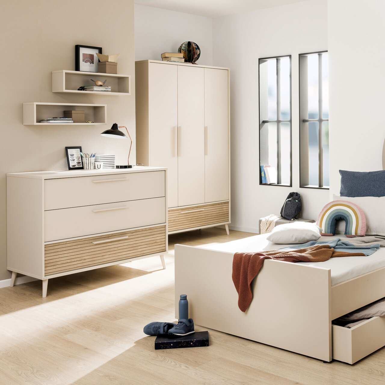 Breite Kommode in einem modernen Schlafzimmer, frontal fotografiert, mit zwei Schubladen und einem offenen Fach, in hellem Holz und Weiß gehalten.