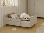 Juniorbett mit Sicherheitsset in einem gemütlichen Kinderzimmer, seitliche Perspektive