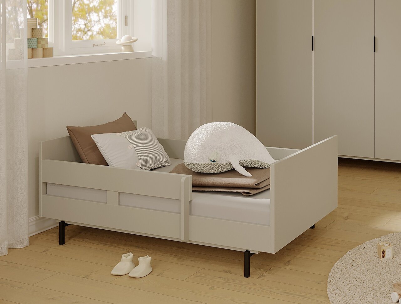 Juniorbett mit Sicherheitsset in einem gemütlichen Kinderzimmer, seitliche Perspektive