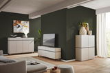 Modernes Wohnzimmer mit TV-Lowboard, Sideboard und Highboard in heller Holzoptik, seitliche Perspektive.