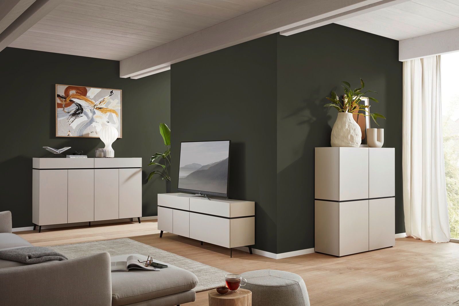 Voleo Sideboard UNIQUE Modernes Wohnzimmer mit TV-Lowboard, Sideboard und Highboard in heller Holzoptik, seitliche Perspektive.