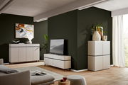 Modernes Wohnzimmer mit TV-Lowboard, Sideboard und Highboard in heller Holzoptik, seitliche Perspektive.