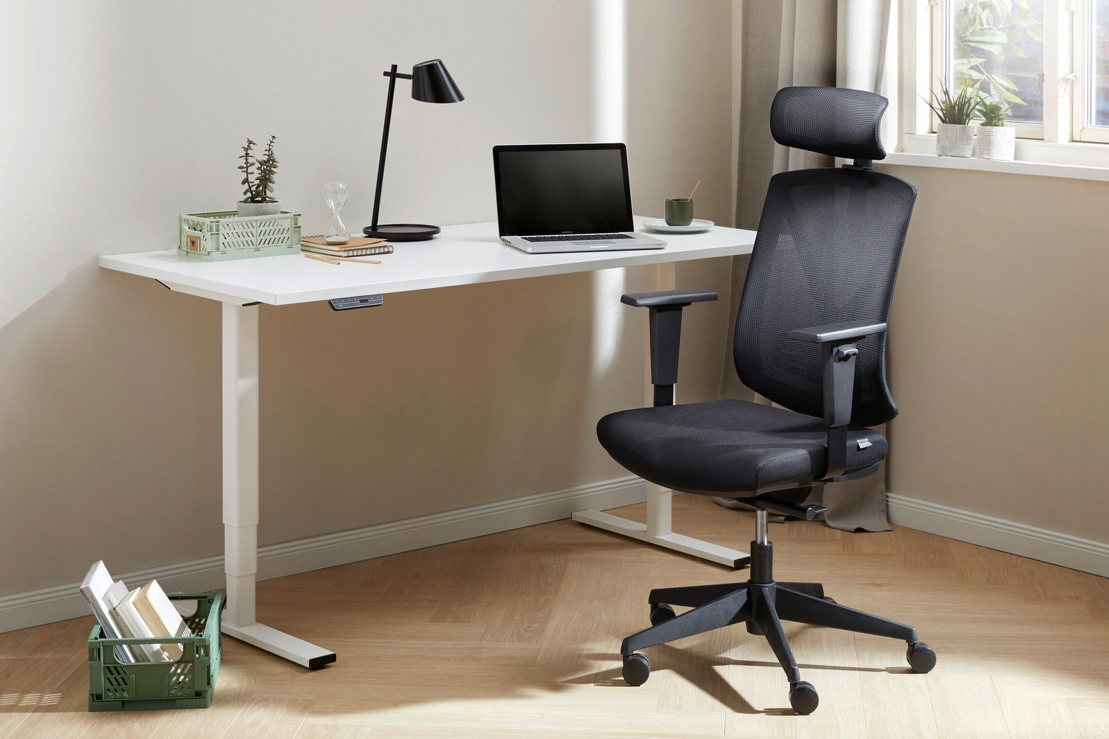 E-Serie E-Schreibtisch E-FLEX Moderner E-Schreibtisch in einem hellen Raum, ausgestattet mit einem Laptop, einer Lampe und Pflanzen, seitliche Perspektive.