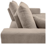 Nahaufnahme einer beigen, gerippten Sofaecke mit zwei großen Kissen, seitliche Perspektive.