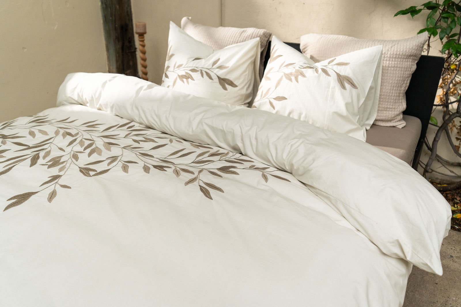 Bettwäsche-Set mit Blattmuster in einem gemütlichen Schlafzimmer, seitliche Perspektive