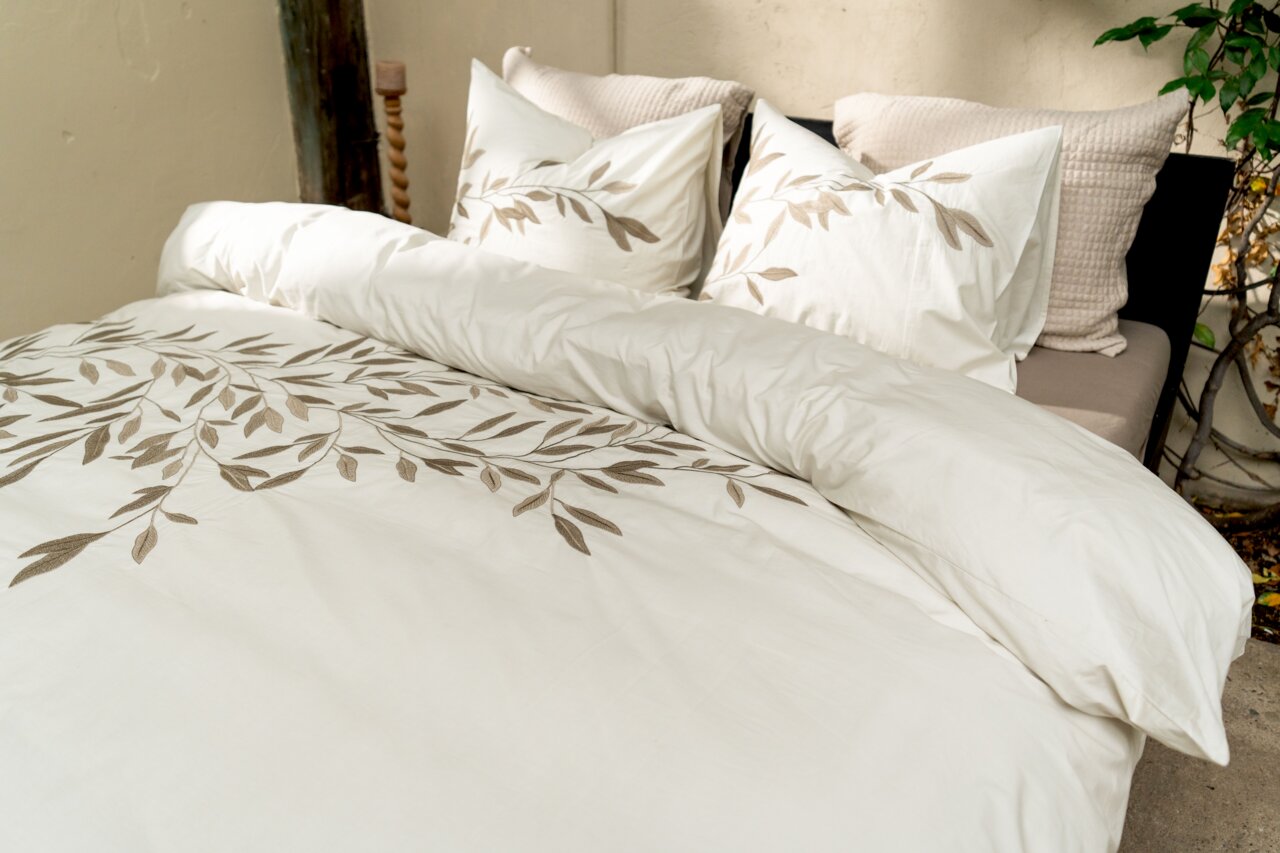 Bettwäsche-Set mit Blattmuster in einem gemütlichen Schlafzimmer, seitliche Perspektive