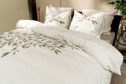 Bettwäsche-Set mit Blattmuster in einem gemütlichen Schlafzimmer, seitliche Perspektive