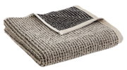 Een opgevouwen handdoek in beige en zwart, gezien vanuit vogelperspectief
