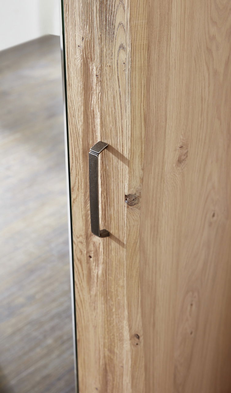 Nahaufnahme eines Garderobenschranks mit Holzmaserung und Metallgriff, seitliche Perspektive