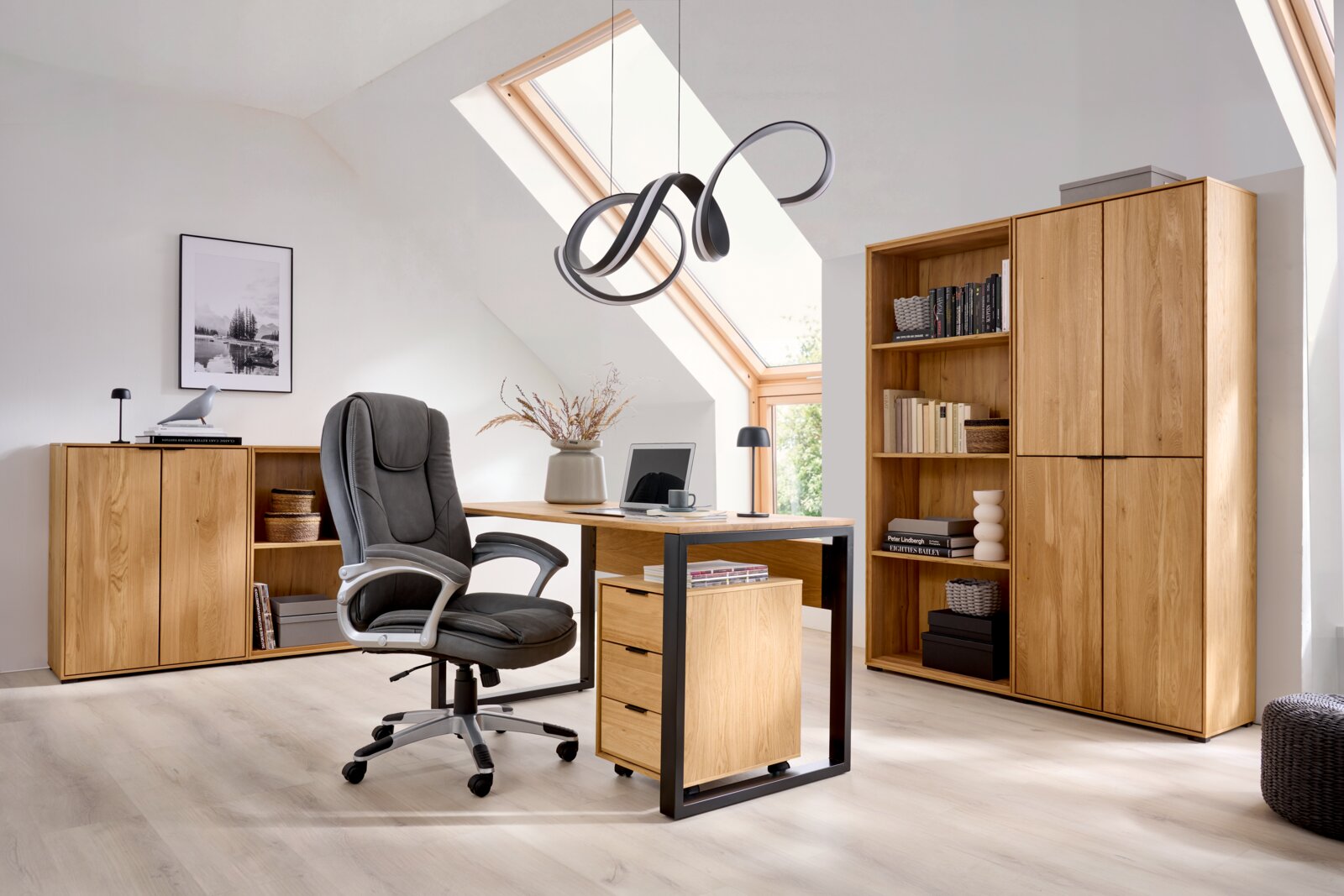 Modernes Homeoffice mit Holz-Schreibtisch und schwarzem Drehstuhl, passenden Holz-Schränken und Bücherregal sowie Design-Deckenleuchte, aufgenommen in leicht schräger Frontalansicht aus Augenhöhe.