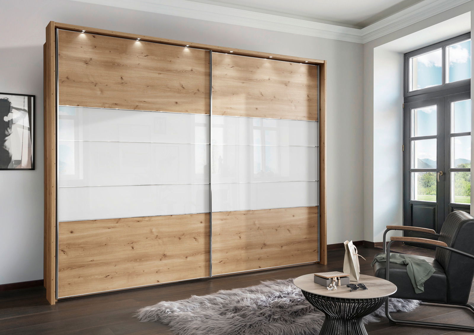 Moderner Schwebetürenschrank mit zwei Türen in Holzoptik und weißen Paneelen, seitliche Perspektive im Wohnzimmer mit natürlichem Licht.