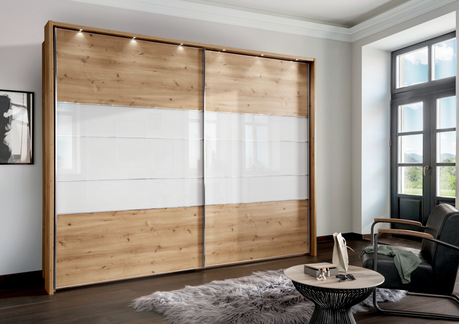 Moderner Schwebetürenschrank mit zwei Türen in Holzoptik und weißen Paneelen, seitliche Perspektive im Wohnzimmer mit natürlichem Licht.