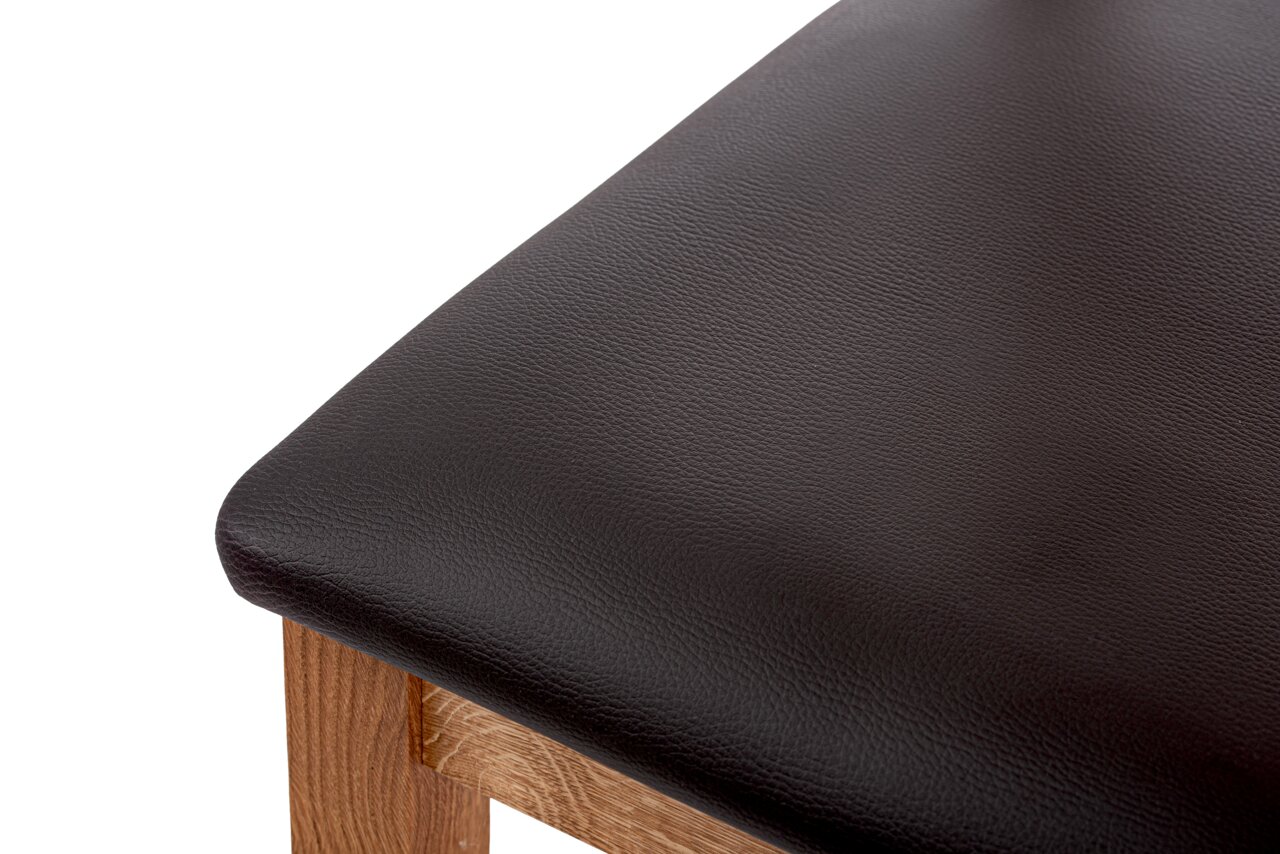 Linea Natura Stuhl ARNOLD Nahaufnahme eines Stuhlsitzes mit schwarzem Lederbezug und Holzgestell, von oben betrachtet.