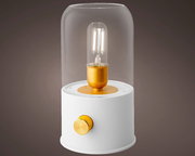 Moderne LED Lampe mit Glasabdeckung und goldenen Akzenten, seitliche Perspektive