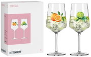 Schräg von vorn fotografiertes Ritzenhoff Cocktail-Gläser-Set in Geschenkbox, daneben zwei bauchige Stielgläser mit Eis und fruchtigen Orange- und Limettenmotiven vor weißem Hintergrund