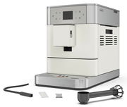 Kaffeevollautomat in seitlicher Perspektive mit Zubehör, darunter ein Schlauch, ein Messlöffel und ein Filter.