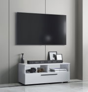 Frontale Ansicht eines modern eingerichteten Wohnzimmers: großer, wandmontierter Flachbildfernseher über einem weißen TV-Lowboard mit Soundbar, Deko und Spielkonsole.