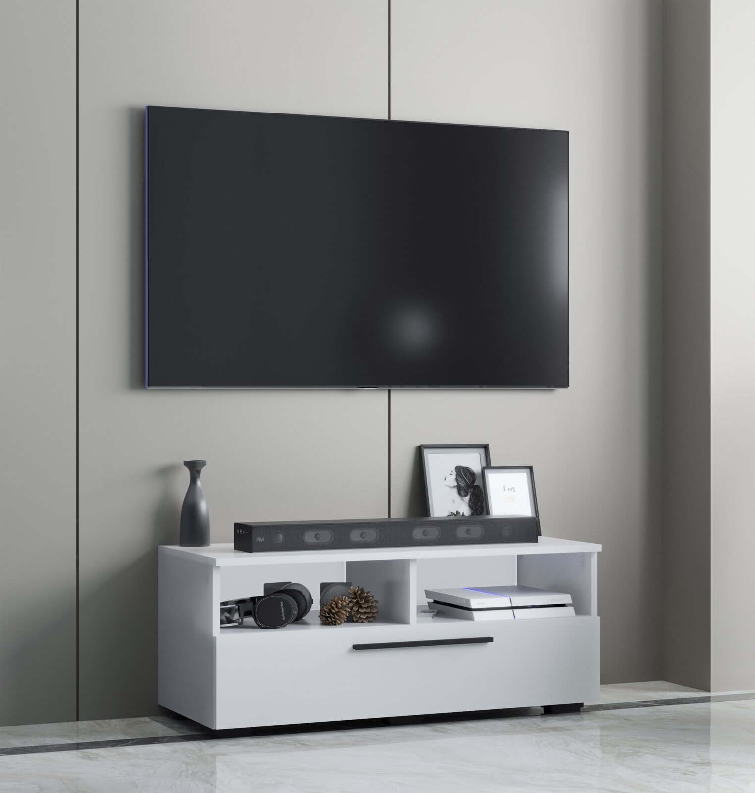 Frontale Ansicht eines modern eingerichteten Wohnzimmers: großer, wandmontierter Flachbildfernseher über einem weißen TV-Lowboard mit Soundbar, Deko und Spielkonsole.