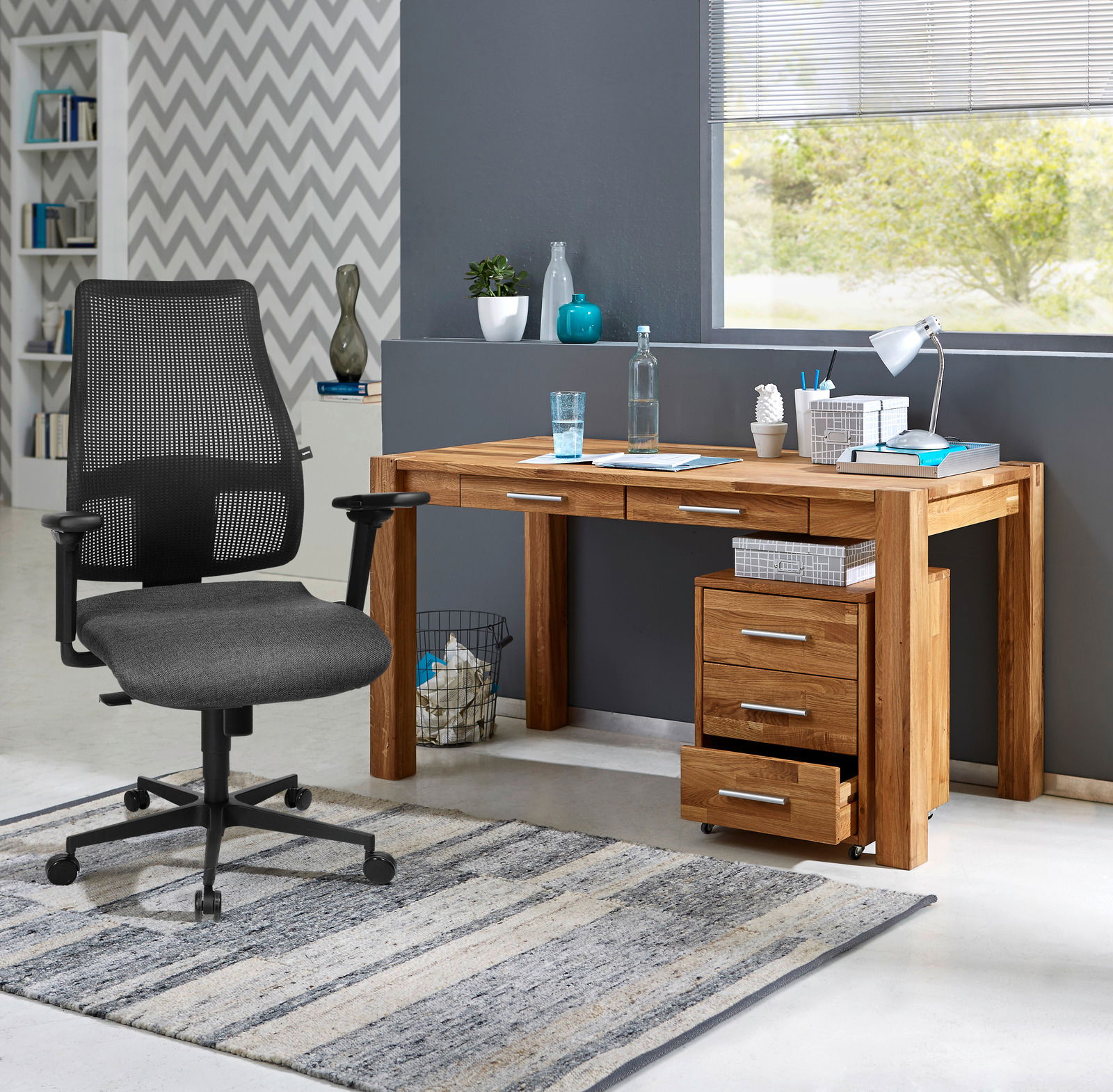 Moderner Rollcontainer aus Holz mit drei Schubladen, unter einem Schreibtisch platziert, seitliche Perspektive.