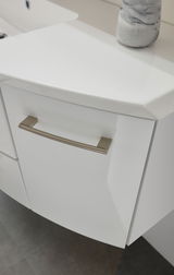 Nahaufnahme eines weißen Badezimmerschranks mit modernem Griff, von oben betrachtet.