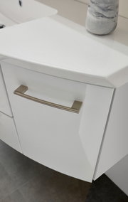 Nahaufnahme eines weißen Badezimmerschranks mit modernem Griff, von oben betrachtet.