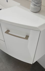 Nahaufnahme eines weißen Badezimmerschranks mit modernem Griff, von oben betrachtet.