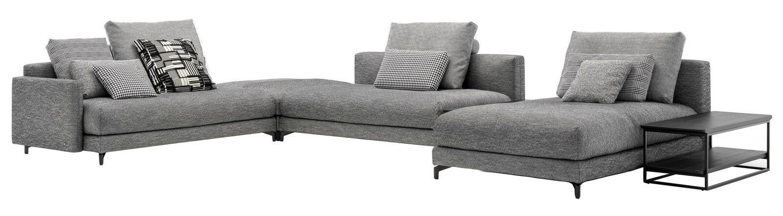 Graue Polsterrundecke mit mehreren gemusterten Kissen, abgebildet aus einer frontalen Perspektive. Rechts befindet sich ein schwarzer Beistelltisch.