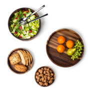 Vogelperspektive auf eine Sammlung von Schalen aus Walnussholz, gefüllt mit Salat, Obst, Brot und Nüssen.