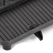 Nahaufnahme eines grauen Geschirrabtropfständers mit Rillen und einem Wasserablauf.