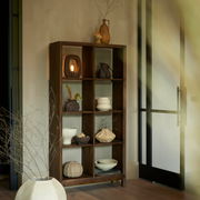 Standregal SONDRI aus Holz mit neun Fächern, dekoriert mit Keramikvasen und Schalen, in einem modernen Raum mit natürlichem Licht, seitliche Perspektive.