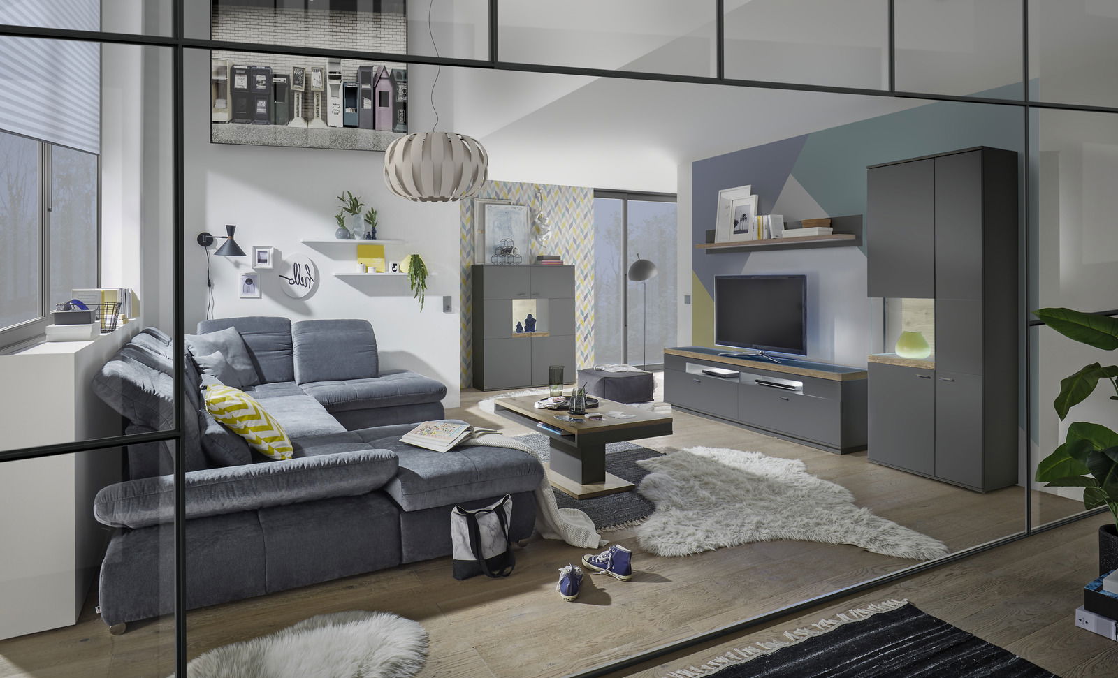 Moderne Wohnzimmeransicht mit grauem Sofa, Couchtisch und Vitrine mit Glasausschnitt links, aus der Perspektive durch eine Glaswand.