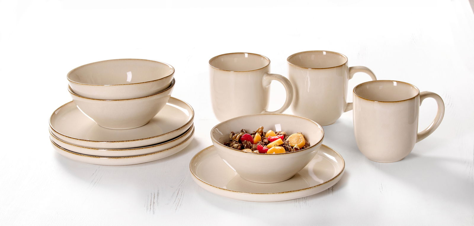 Frühstücksset Olivia 12-tlg. in cremefarbenem Design, bestehend aus Tellern, Schalen und Tassen, auf weißem Hintergrund aus seitlicher Perspektive.