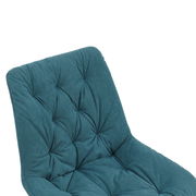 Nahaufnahme eines gepolsterten Stuhls mit grünem Stoffbezug und gestepptem Muster, Ansicht von schräg oben.