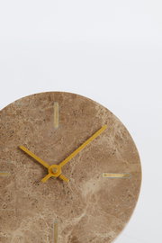 Nahaufnahme einer runden Uhr aus braunem Marmor mit goldenen Zeigern und Markierungen, frontal betrachtet.