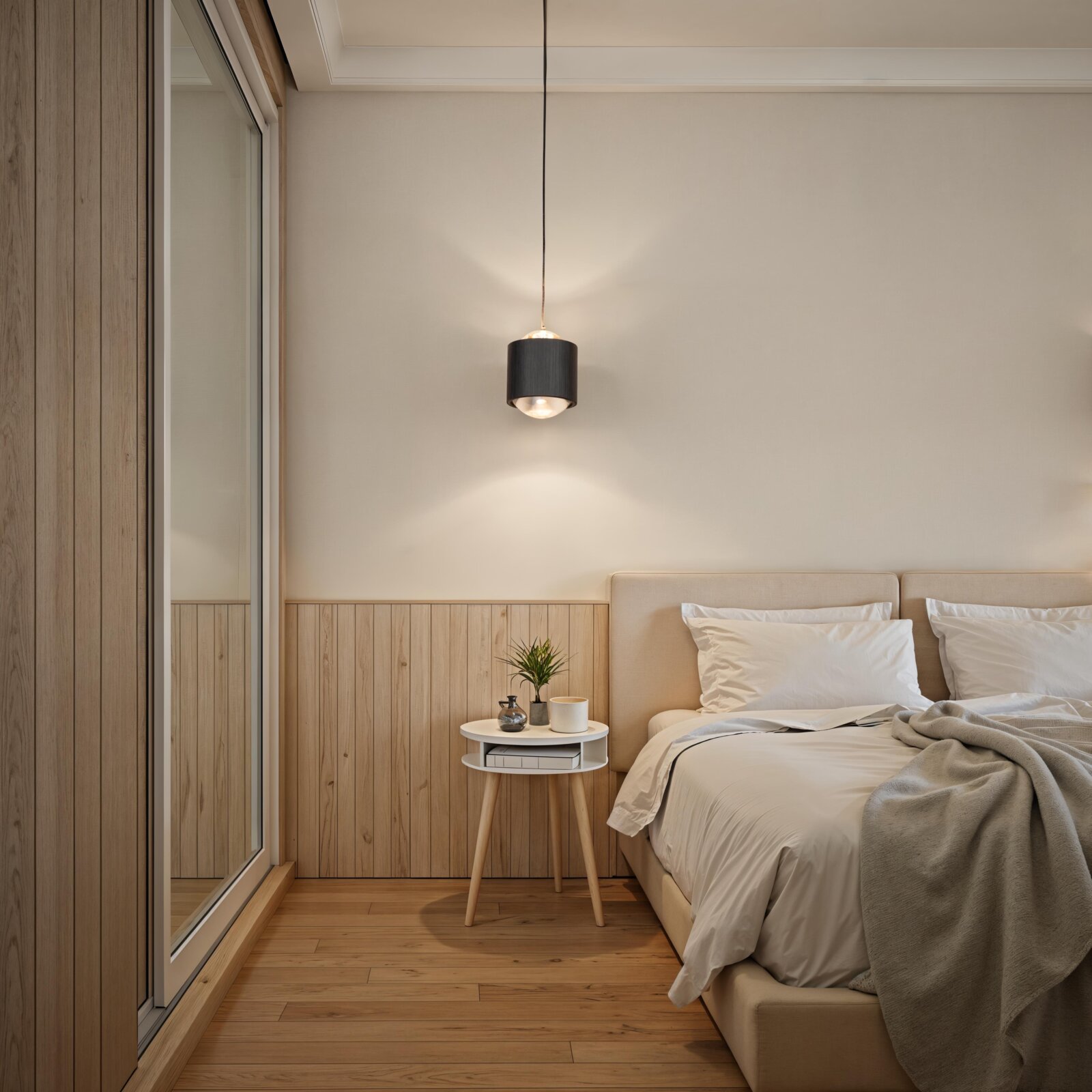 Moderne schwarze zylindrische Pendelleuchte mit warmem Licht über einem Bett und einem weißen Nachttisch im minimalistischen Schlafzimmer, frontale Innenraumansicht