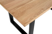 Nahaufnahme eines Esstisches mit einer Holzplatte und schwarzen Metallbeinen, aus der Perspektive von oben.