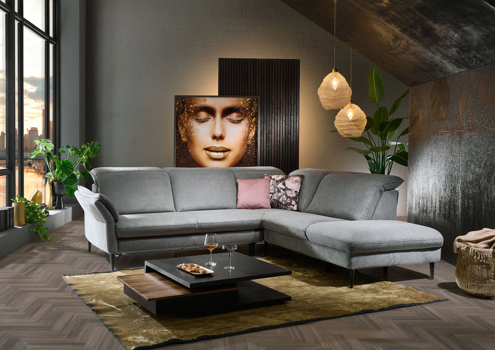 Graue Eckgarnitur in modernem Wohnzimmer, seitliche Perspektive, mit dekorativen Kissen und Couchtisch auf Teppich.