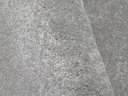 Nahaufnahme eines grauen Uni-Teppichs mit weicher, flauschiger Textur, perspektivisch von der Seite aufgenommen.