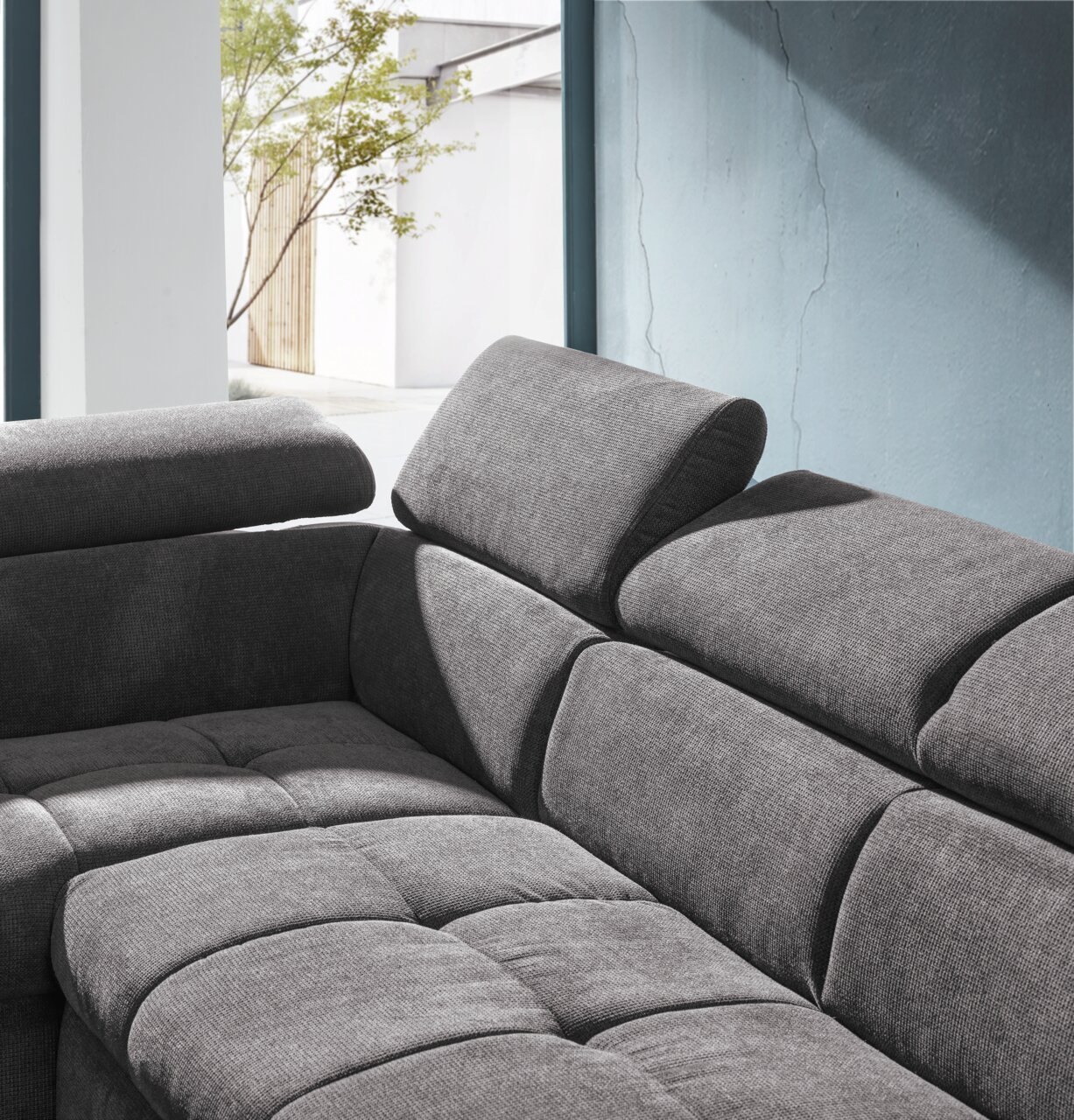 Graue Eckgarnitur mit verstellbaren Kopfstützen, seitliche Perspektive