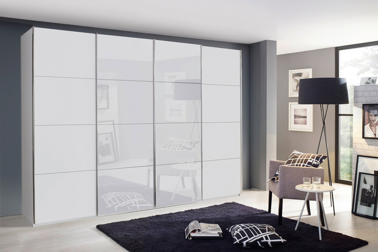 Moderner Synchron-Schwebetürenschrank in Weiß, seitliche Perspektive, in einem stilvoll eingerichteten Raum mit grauem Teppich und dekorativen Kissen.